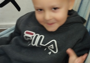 Chłopiec siedzi w hamaku.