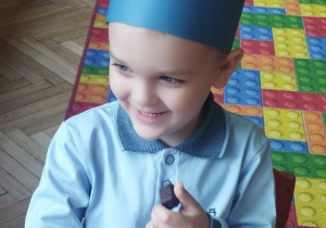 Chłopiec jedzący cukierka przy stoliku