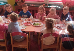 Grupa dzieci je wspólny podweczorek.