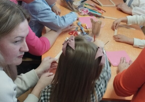 Dzieci wraz z rodzicami tworzą ozdoby podczas zajęć kreatywnych