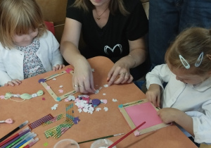 Dzieci wraz z rodzicami tworzą ozdoby podczas zajęć kreatywnych
