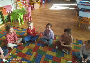 Dzieci podaja sobie dynie