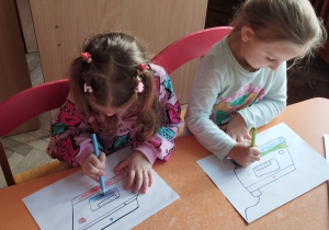 Grupa dzieci koloruje żelazka według podanego kodu.