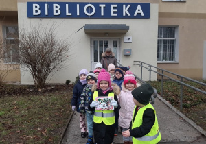 Dzieci przed budynkiem biblioteki