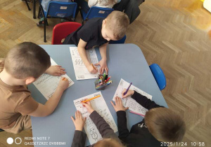 dzieci uzupełniają karty pracy