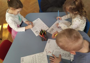 dzieci uzupełniają karty pracy