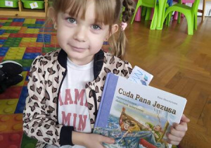 dziewczynka pokazuje książkę